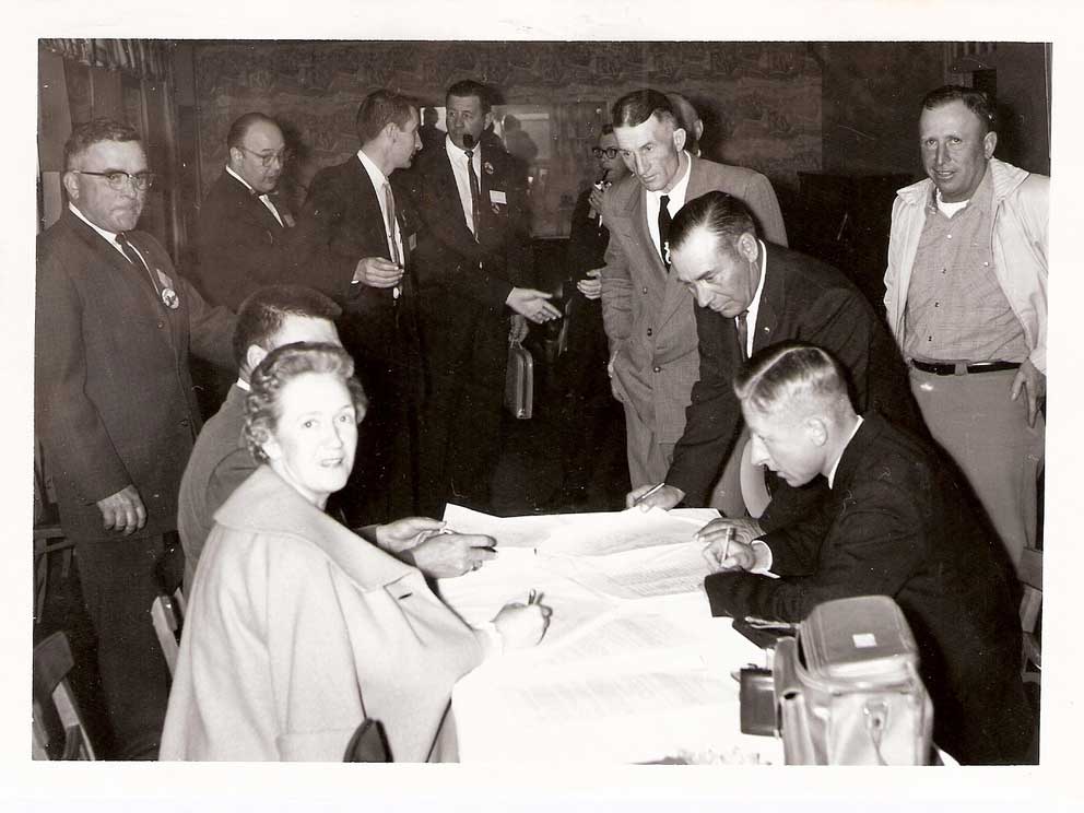 People gathered around a desk signing Basin Electric’s Articles of Incorporation