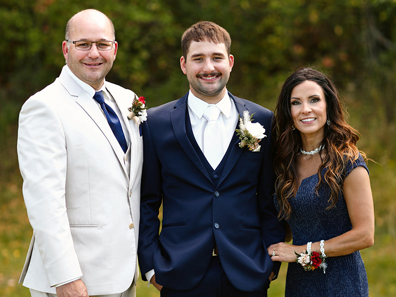 Dawson Kaylor stands between his parents at an event