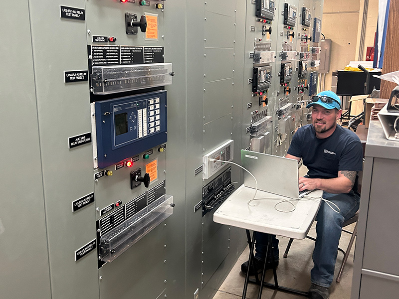 System protection technician plugged into a protective relay