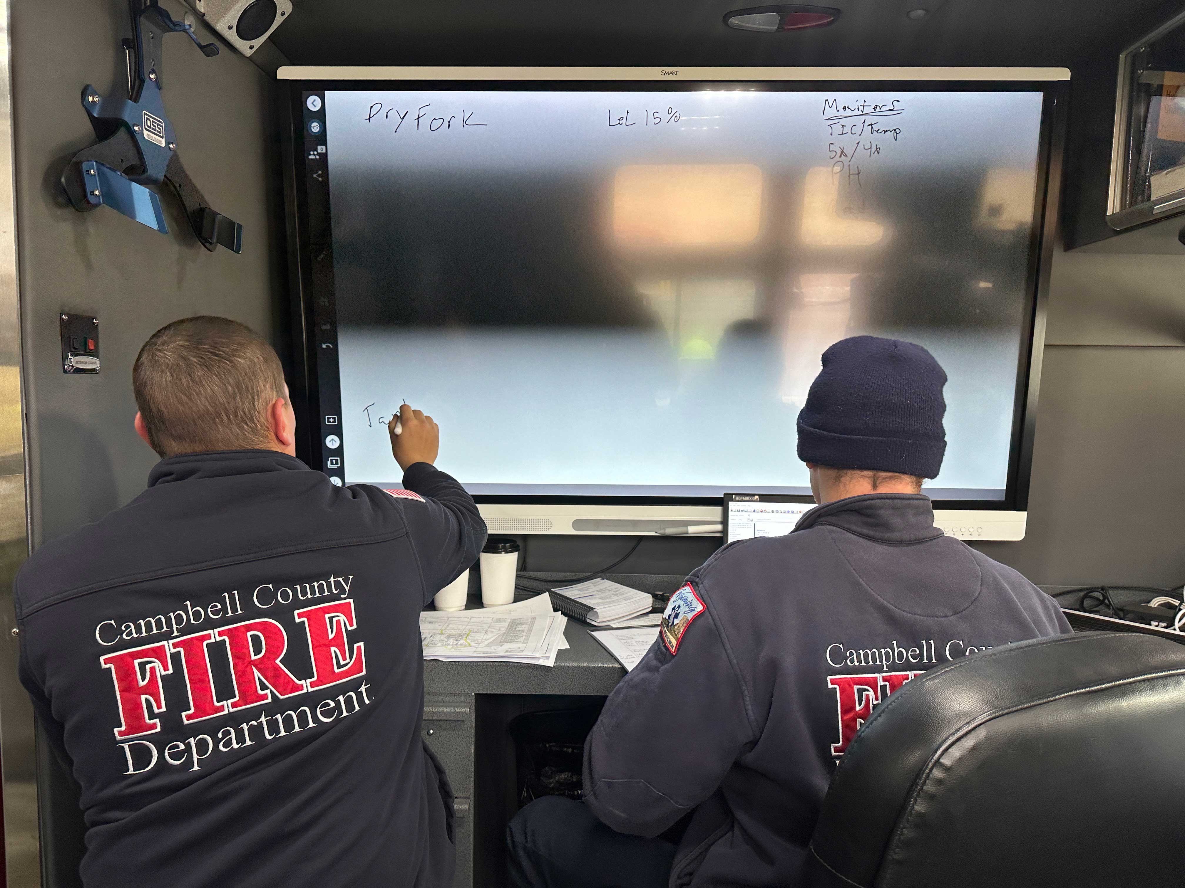 Firefighters working at large screen during a training exercise.