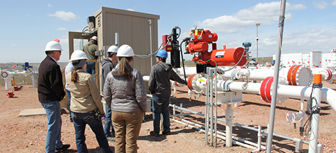 People in hard hats viewing the pipeline