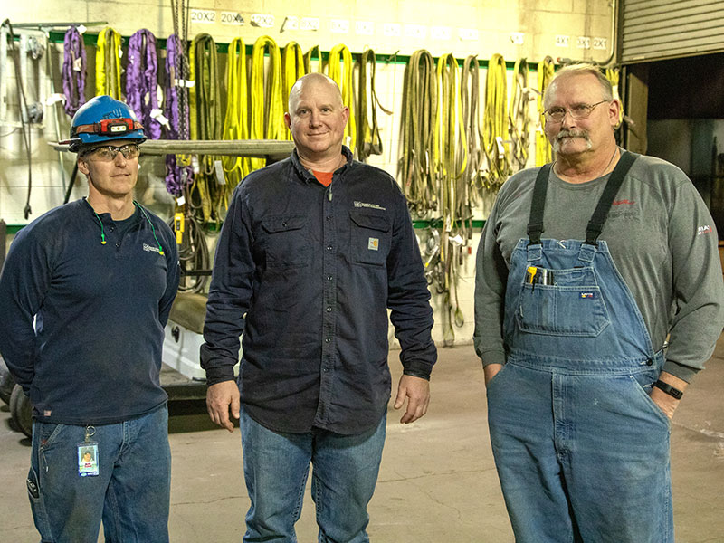 three men standing in shop